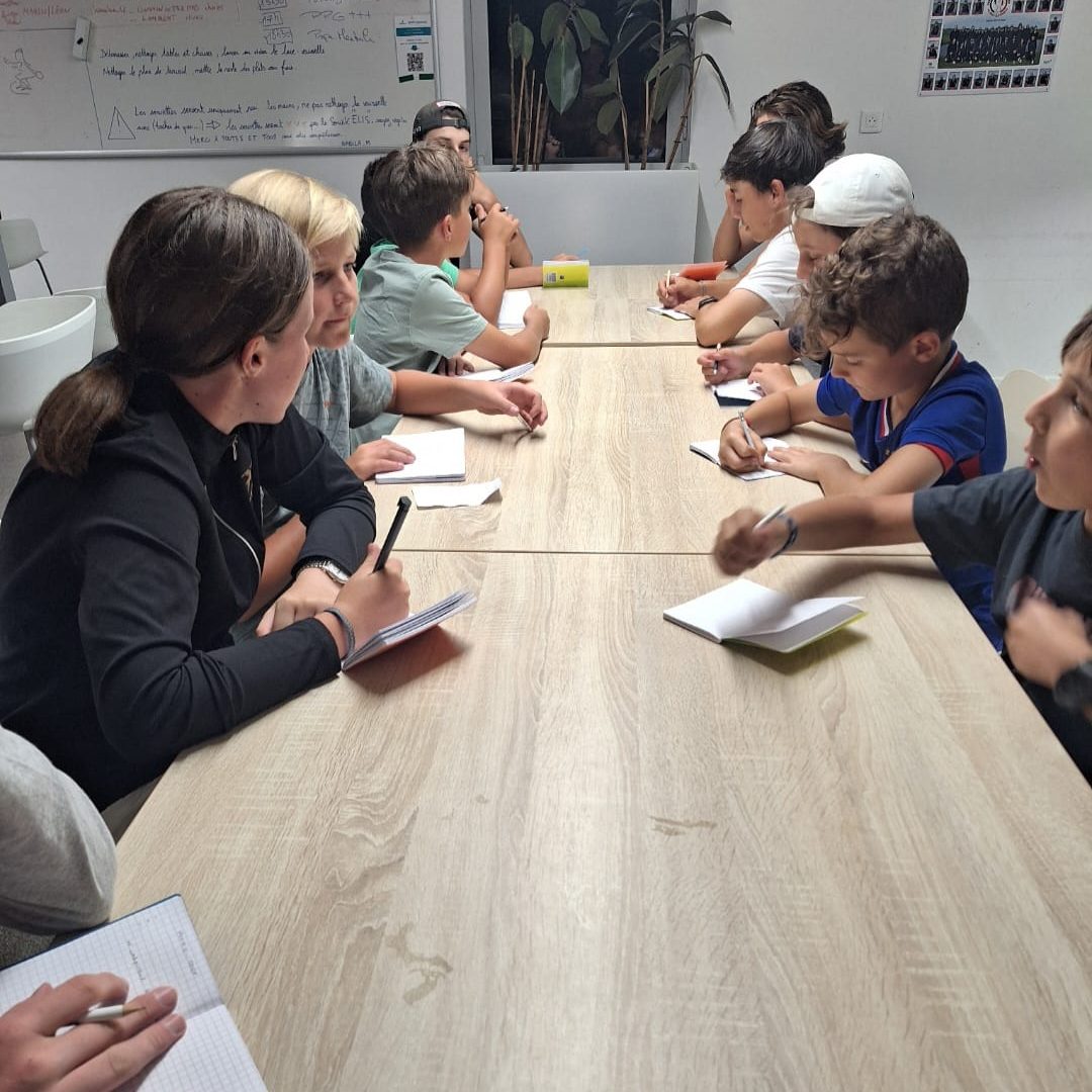 Jeunes golfeurs assistant à un cours théorique lors d’un stage de golf au Golf National