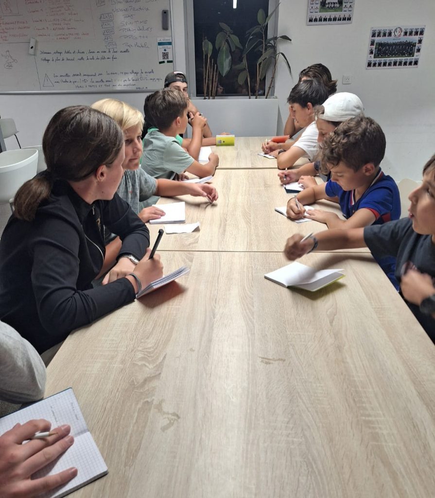 Jeunes golfeurs assistant à un cours théorique lors d’un stage de golf au Golf National